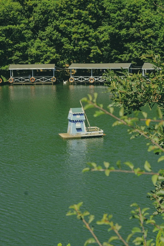 a houseboat in the water near the shore of a lake