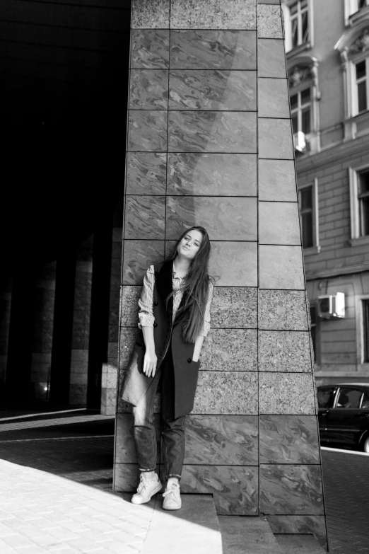 a woman standing next to a building in front of it