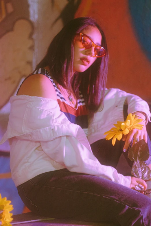 a woman sitting on top of a bench holding a flower