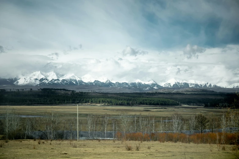 an empty field with snow capped mountains in the background