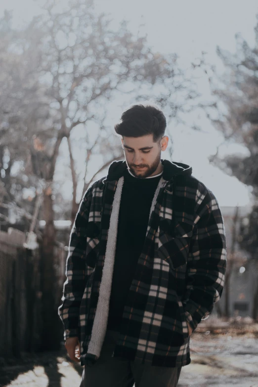 a young man in a jacket stands outside