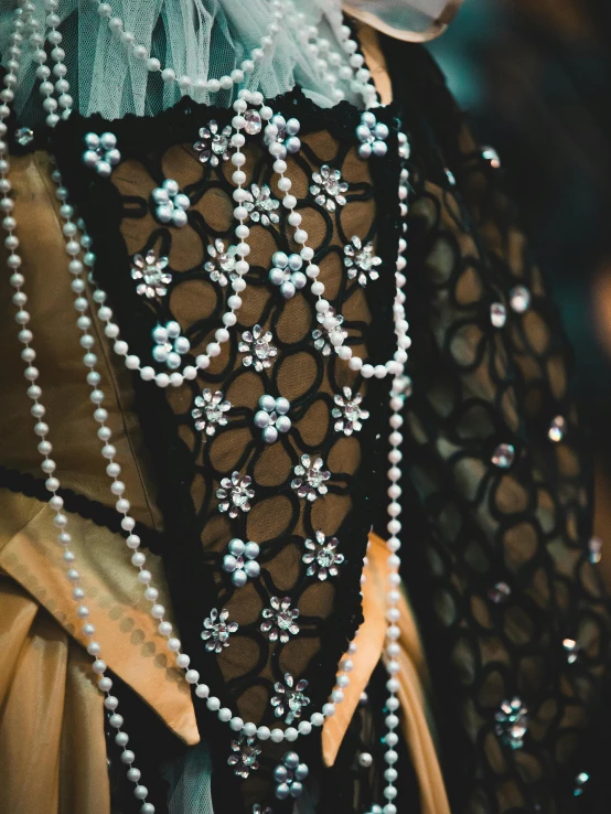 a close up view of the neck, collar and necklace on this woman