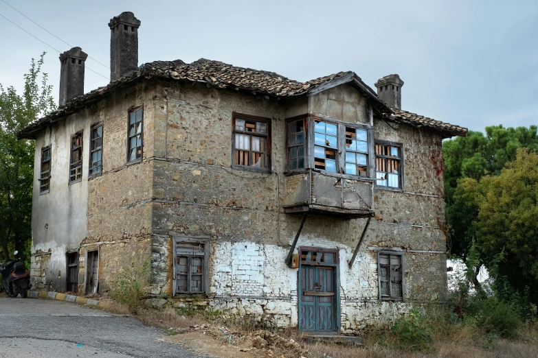 a rundown house sitting on the side of a road