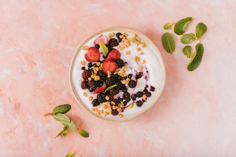 the yogurt with berries and nuts is on top of the leaves