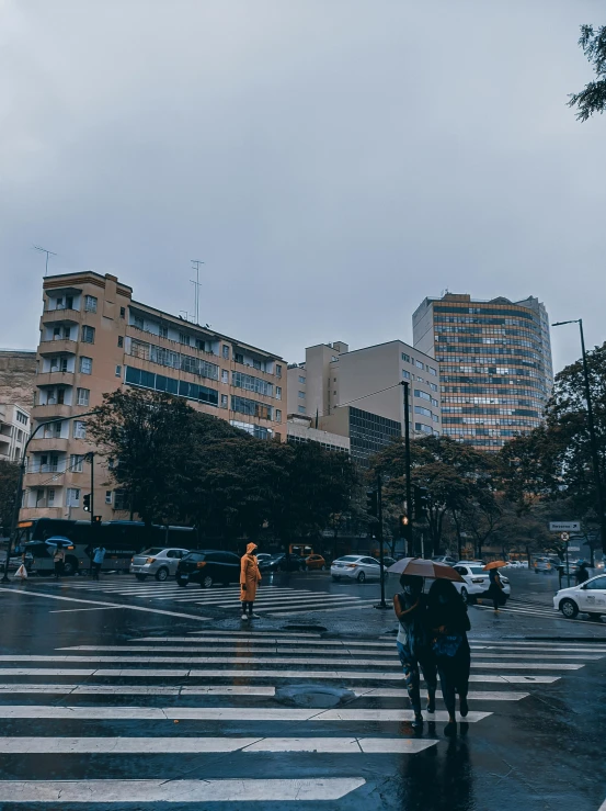 two people standing on the corner with an umbrella