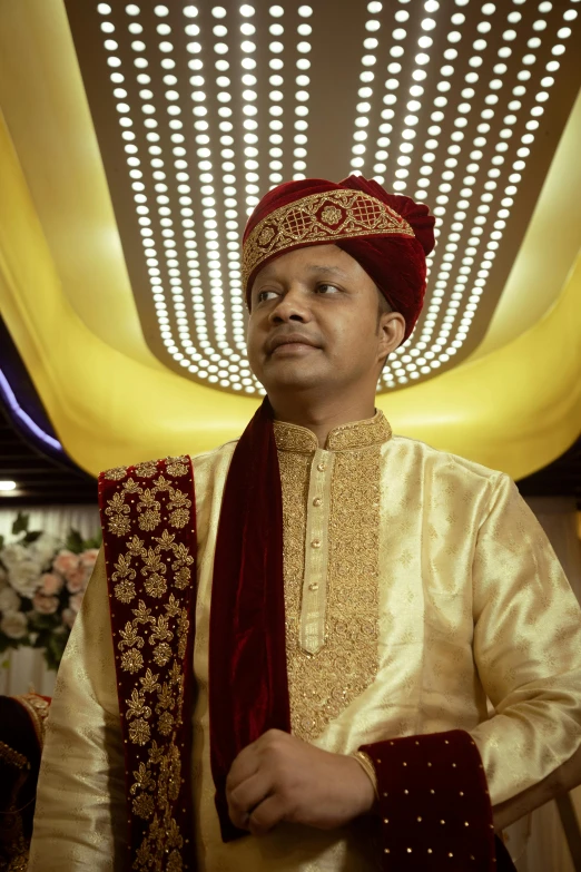 a man wearing a traditional indian garb in the midst of floral decorations