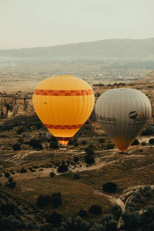 two large  air balloons sitting in the middle of a field