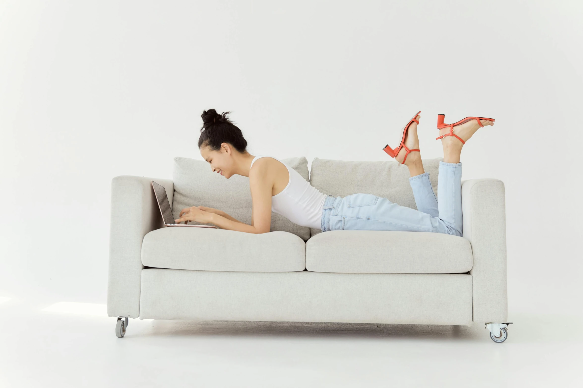 a woman laying on a couch with her feet up and a laptop