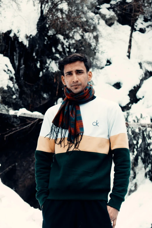 a man in green and white stands near snow