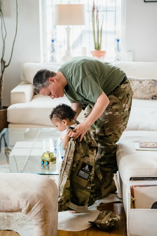 a man helping a child adjust his shoes in the living room