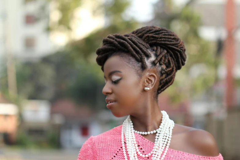 woman in pink sweater wearing three strand beaded necklace