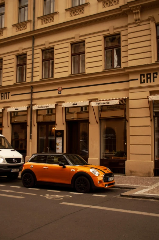 two orange and white mini cabs are parked near a building