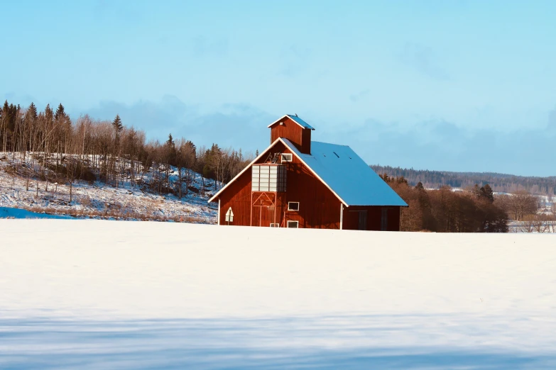 a snowy mountain scene with a barn on top