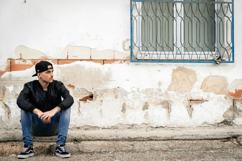 a man sitting on a bench next to an old building