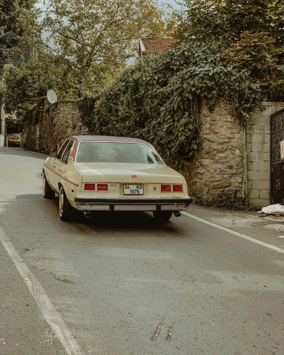 a tan car that is sitting on a street