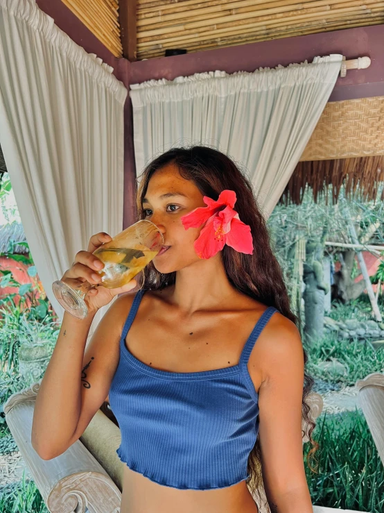 the young woman is enjoying her drink in the park