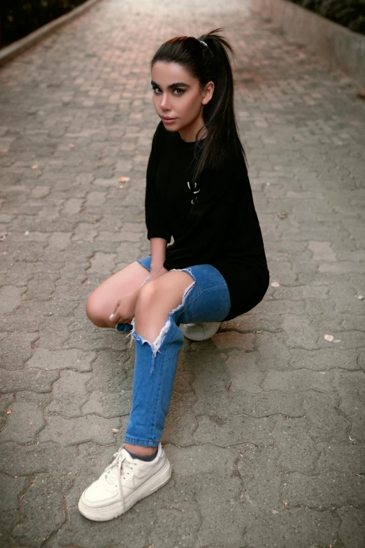 a young woman sitting on the floor with her legs crossed