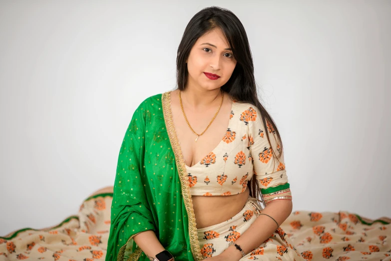 a woman in green and white clothing sits down