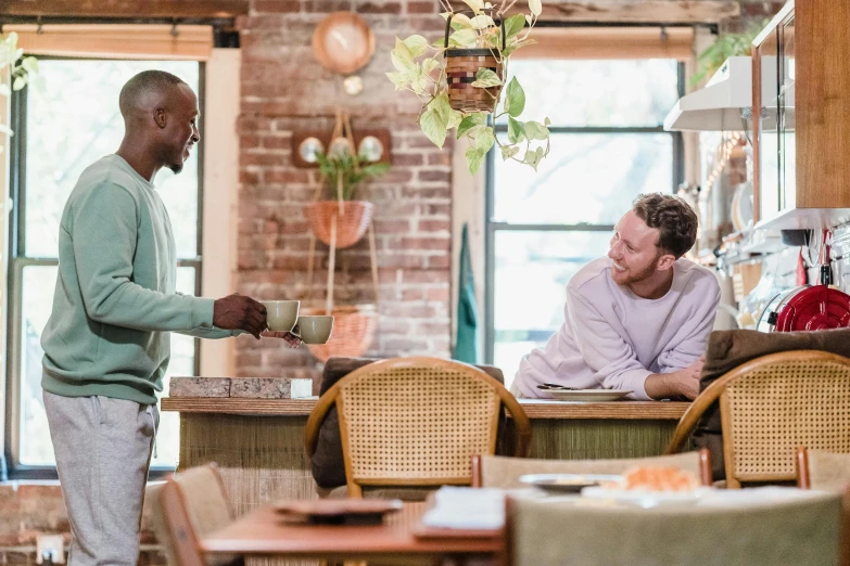 three men standing around talking in a restaurant