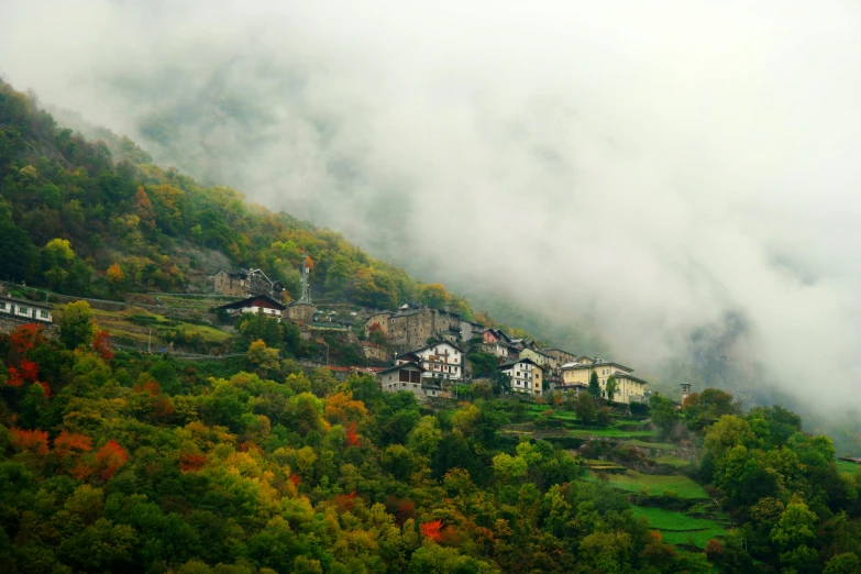 village on top of small hill with low lying clouds