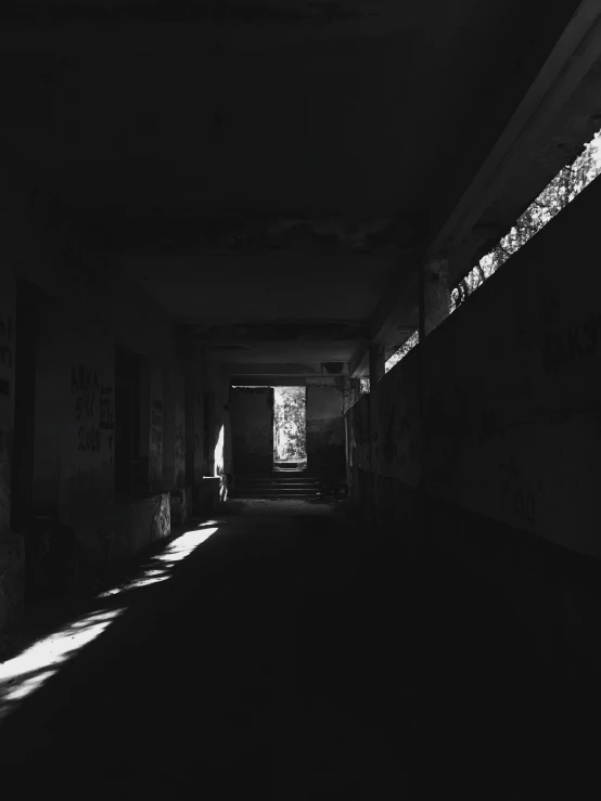 dark, drab corridor with lots of graffiti on the walls
