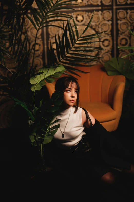 an image of a girl sitting on a chair with a plant in her lap