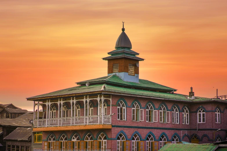 a colorful sunset glows over a tall, ornate building