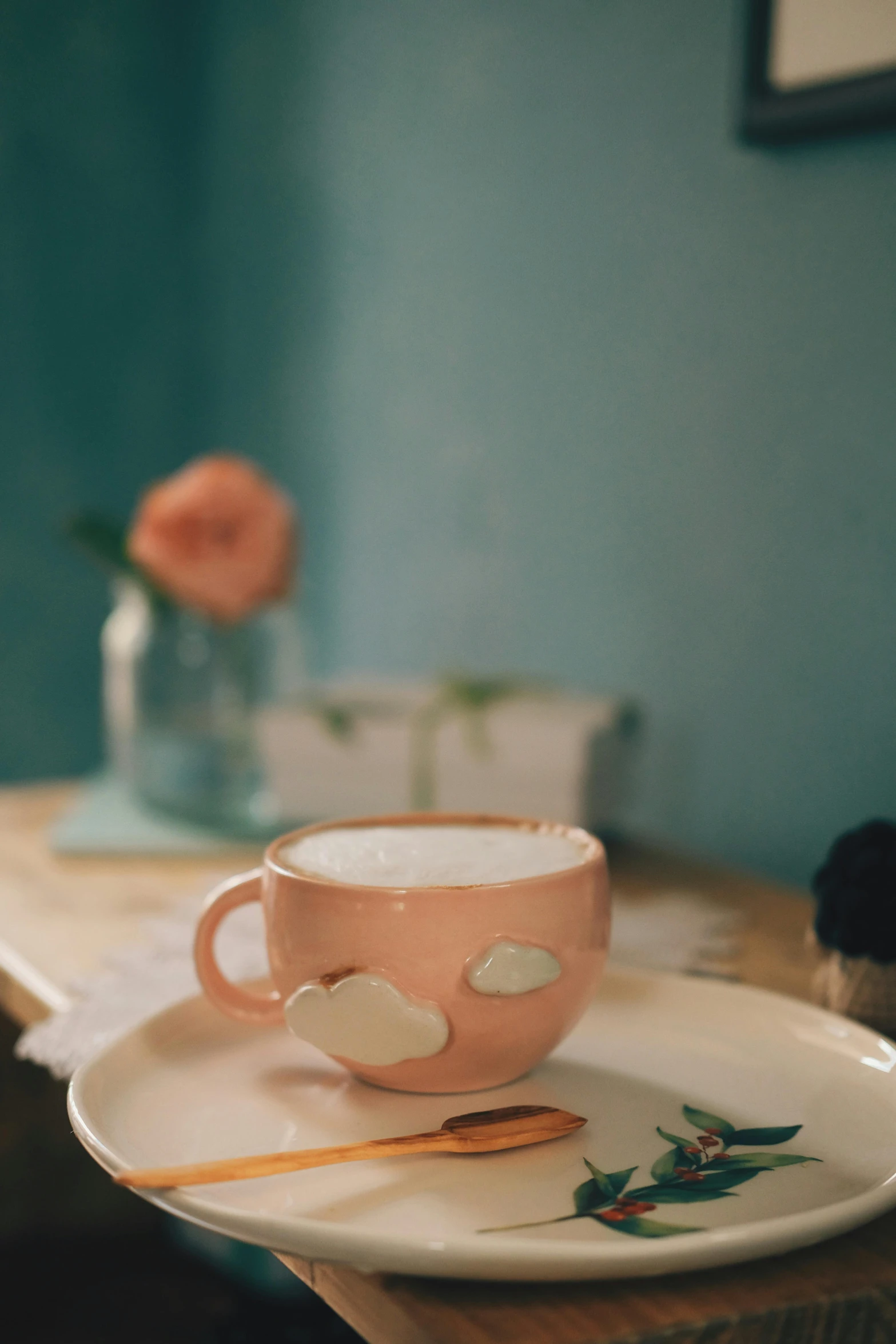 a cup with flowers on the side and some chopsticks in front of it