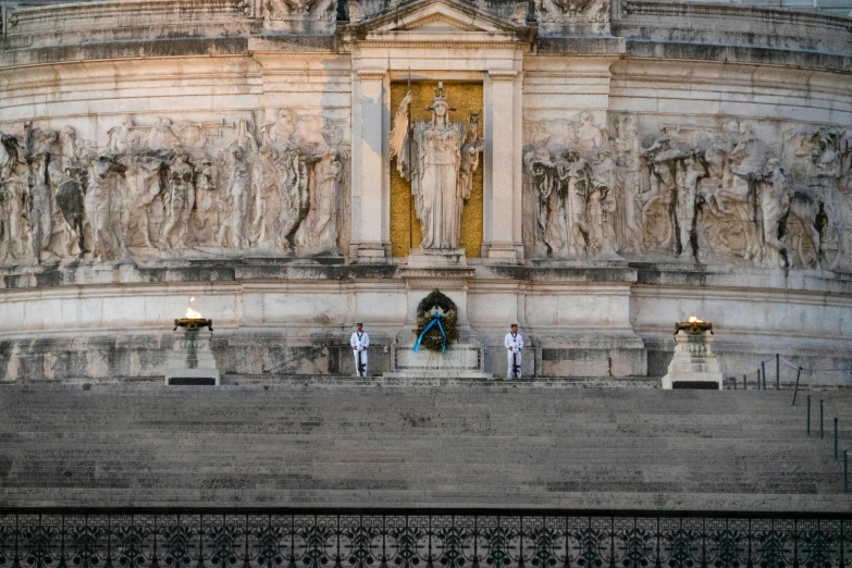 two men and a woman sitting at the base of a large building