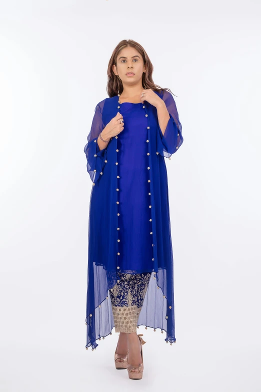 the model wears a blue gown with sheer sleeves and a beaded top