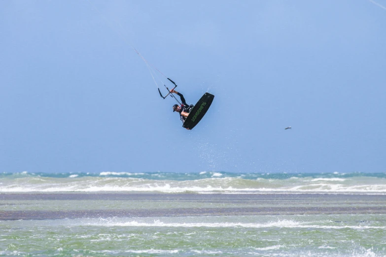 a person riding water skis while attached to a parachute