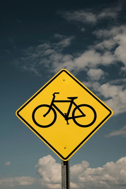 a yellow sign with a bicycle on it