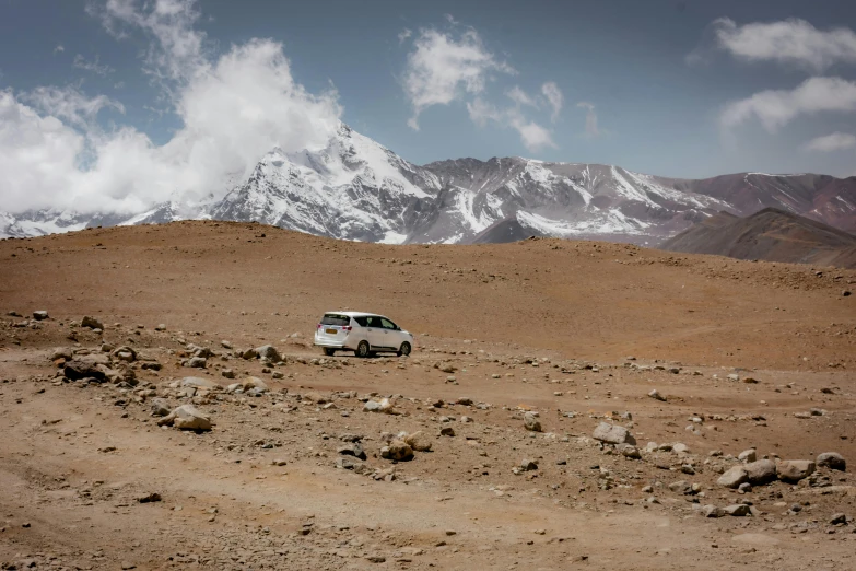 a small truck traveling across a dirt covered field