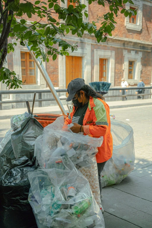 a man is holding a pole next to large bags and garbage
