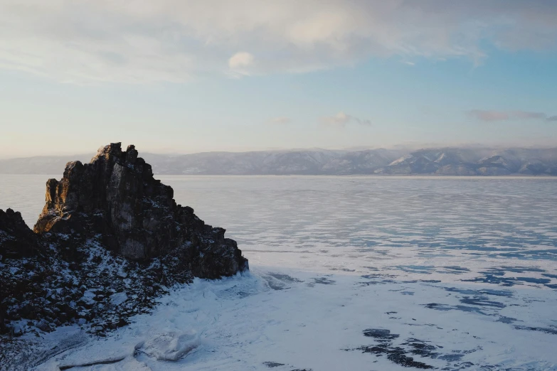 a lone piece of ice sitting in the middle of a lake