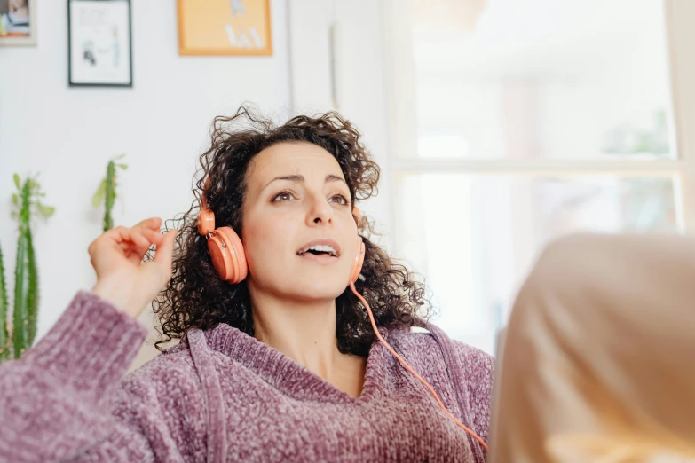 a woman holding two old earphones in her ears