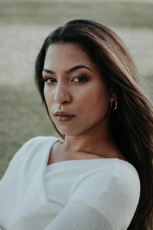 a woman is sitting outside posing for a po