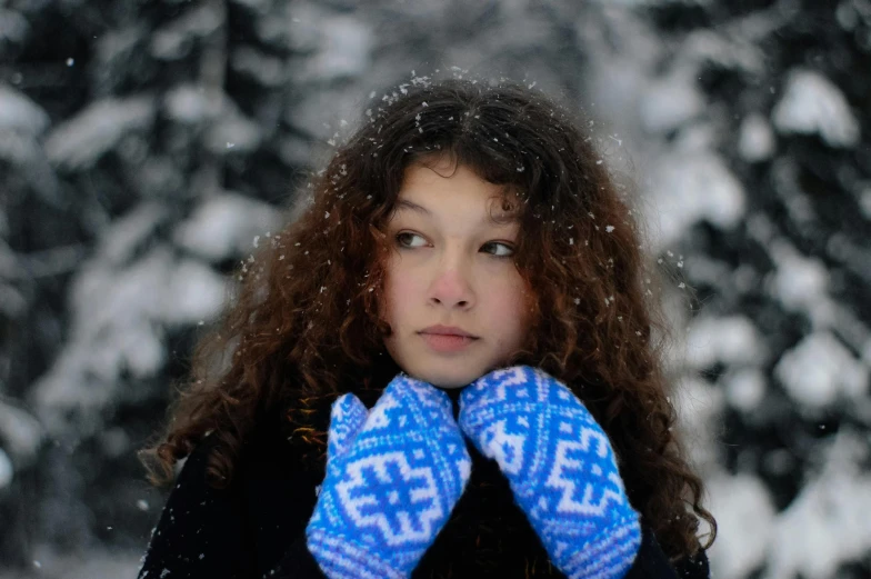 a woman wearing a hat and gloves in the snow