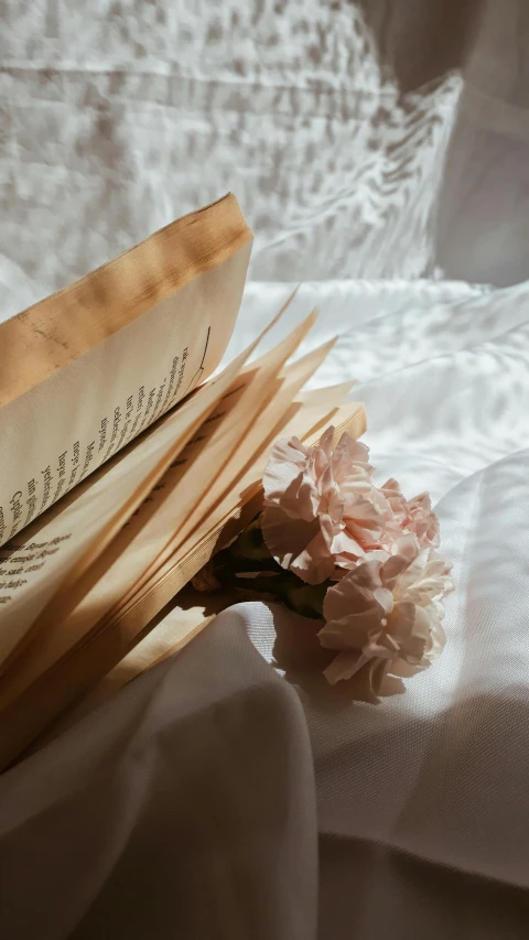 an open book sitting on top of a white cloth