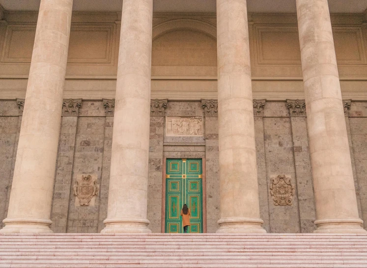 an open door sits between three tall columns