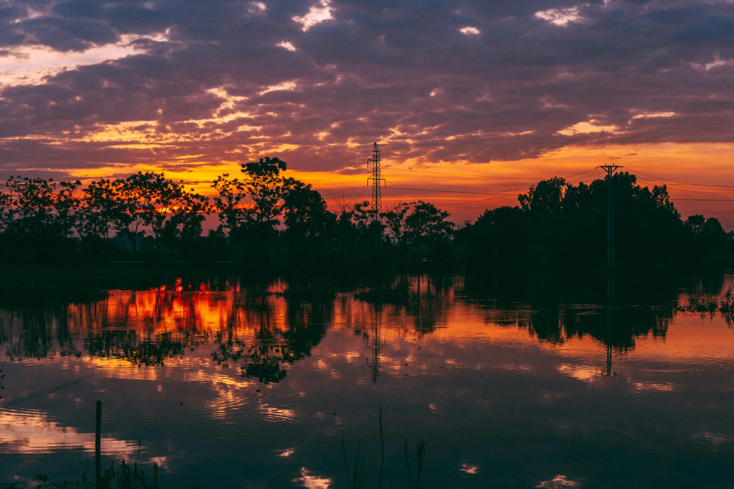 a lake filled with water and clouds under a purple sky