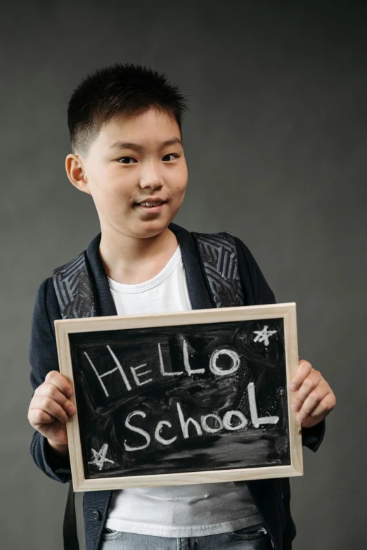 a  holding a sign that says hello school