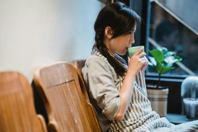 the woman is using her phone and having a drink