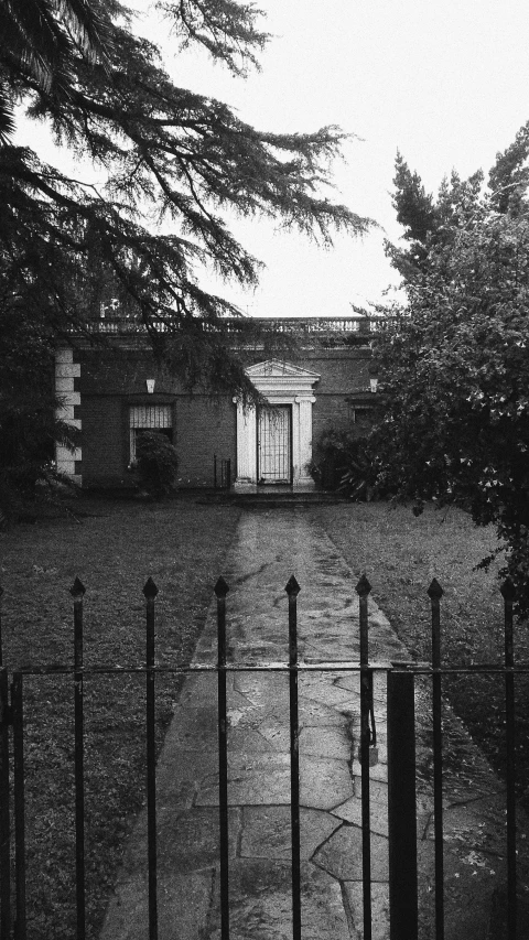 black and white pograph of building behind a fence