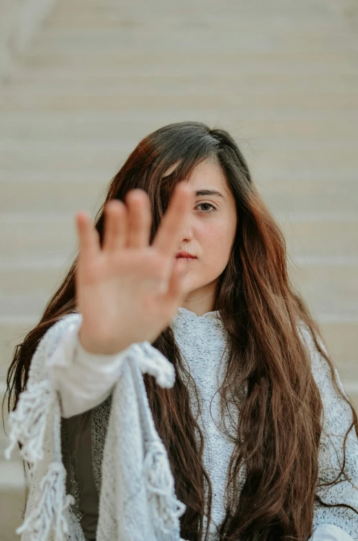 young woman taking selfie on stairs with one hand up