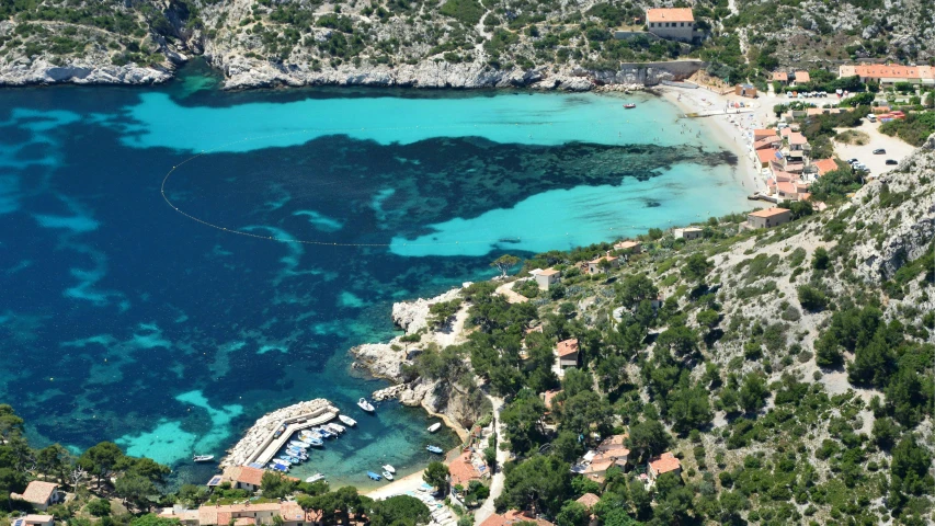 this aerial view of a rocky and blue beach looks like a lagoon