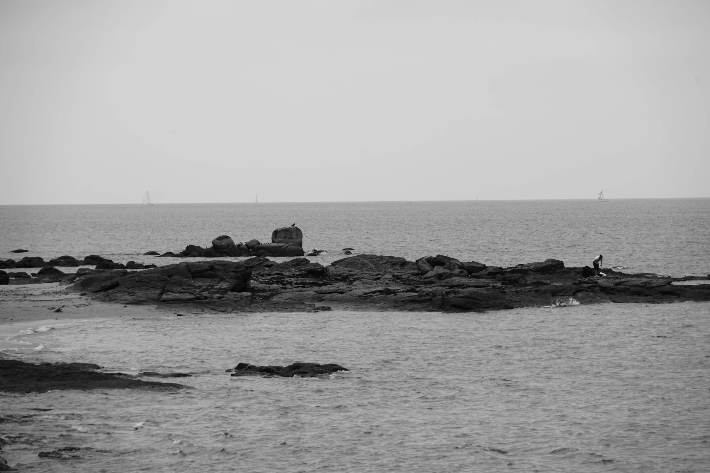 a man fishing off a small rocky island