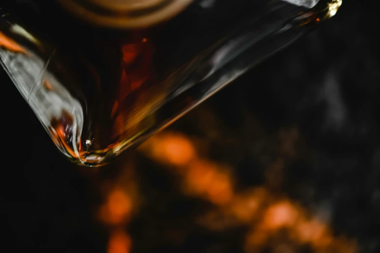 the bottom of a wine glass with orange streaks on it