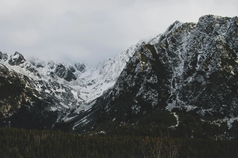 some mountains with snow covered top against the sky