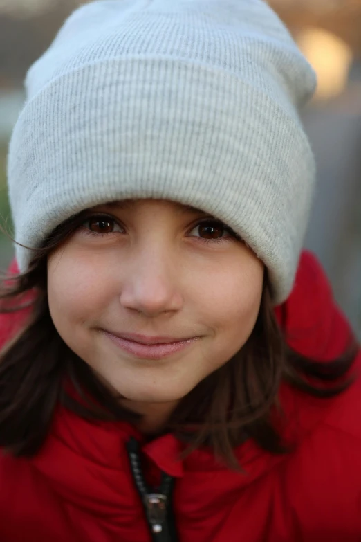 the girl with the white hat is wearing a red sweater